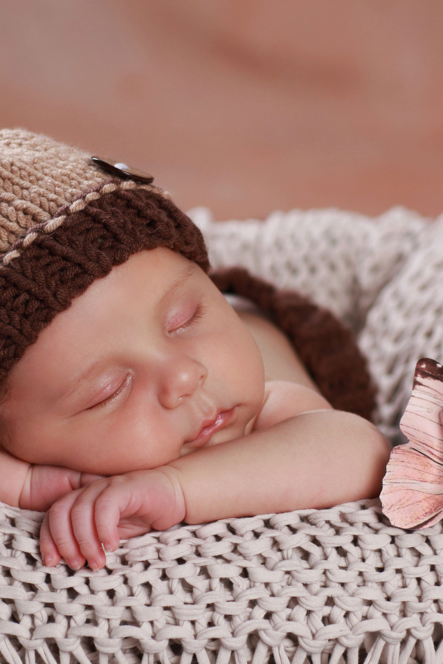 Cute sleeping baby in a brown knitted hat