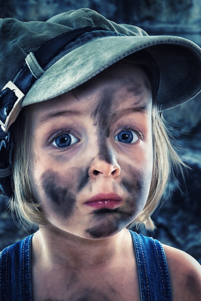 Смешная девочка в кепке с грязным лицом