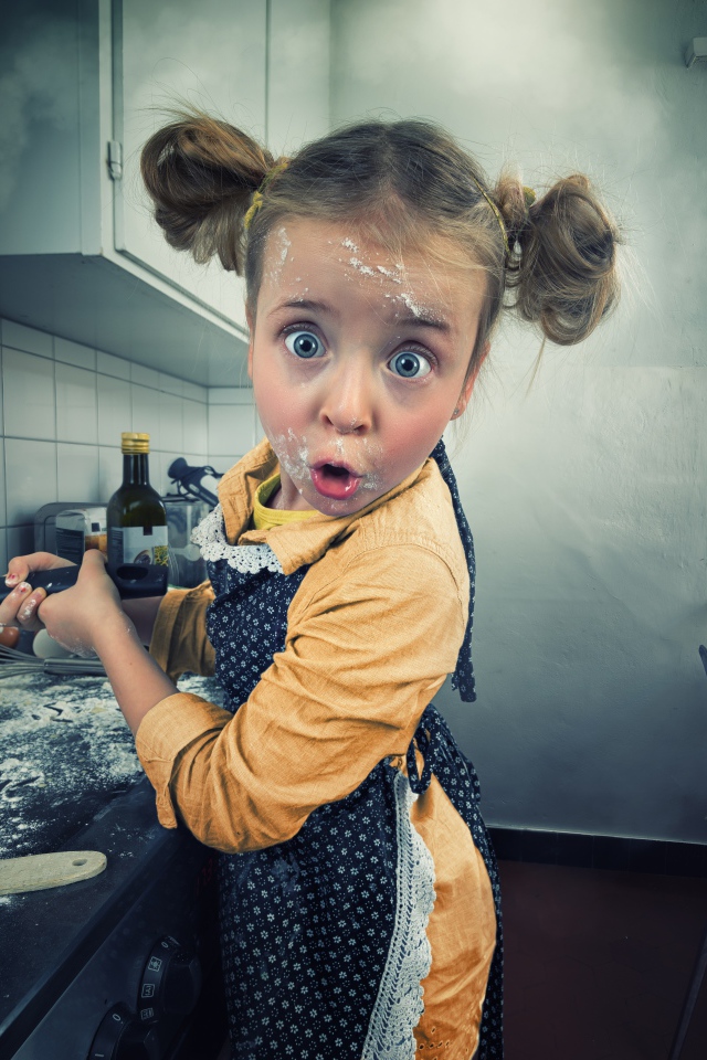 Смешная маленькая девочка готовит блины