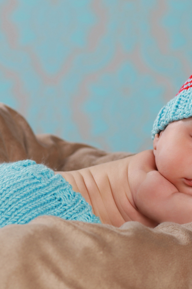 Забавный спящий младенец в голубом вязаном костюме 