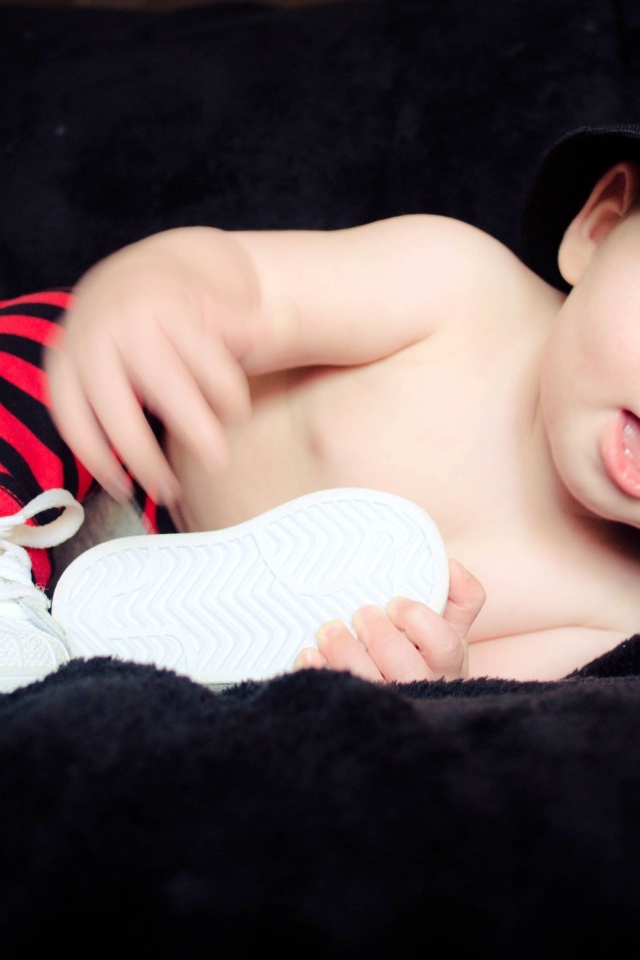 Забавный улыбающийся ребенок в черной панаме