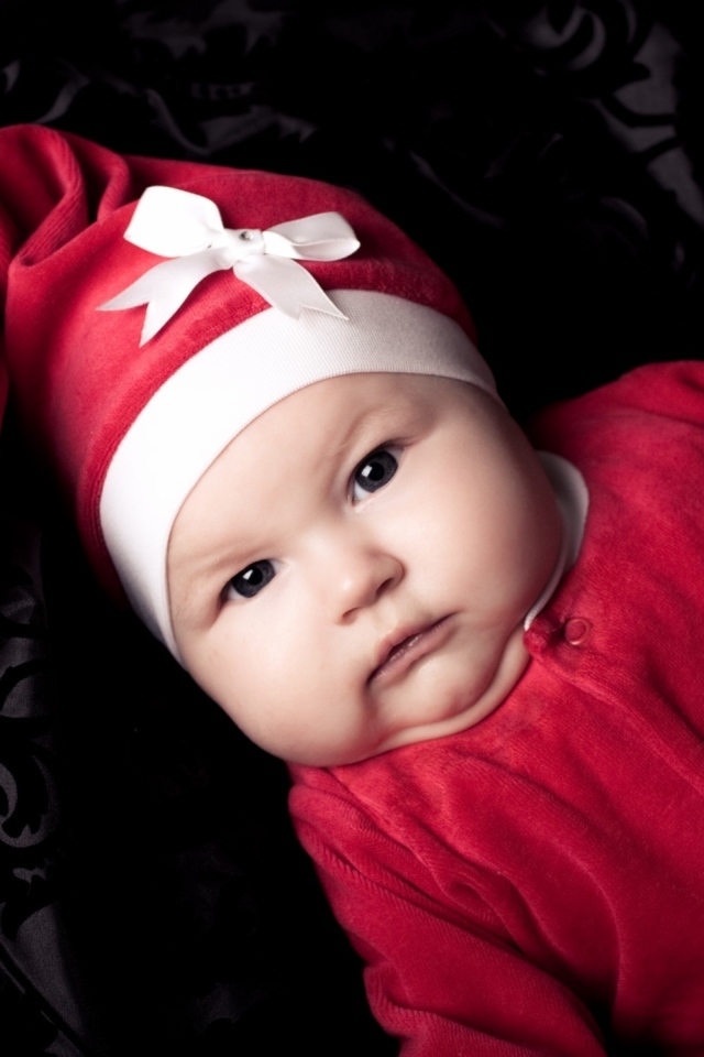 Грудной ребенок в красном новогоднем костюме