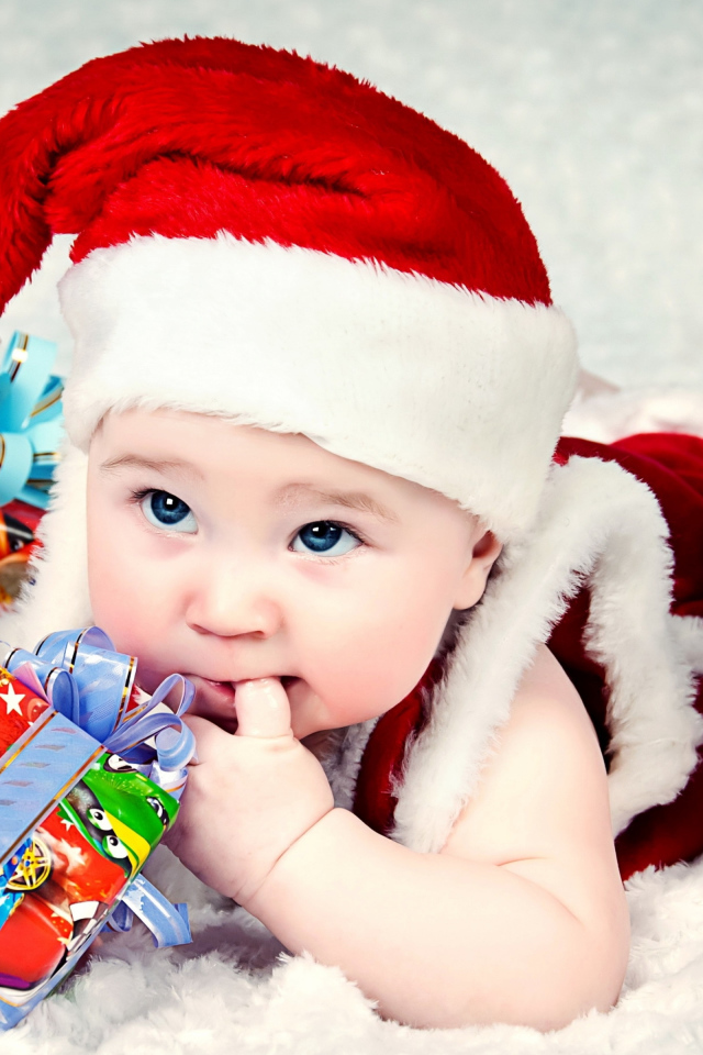 Маленький ребенок в новогоднем костюме с подарками