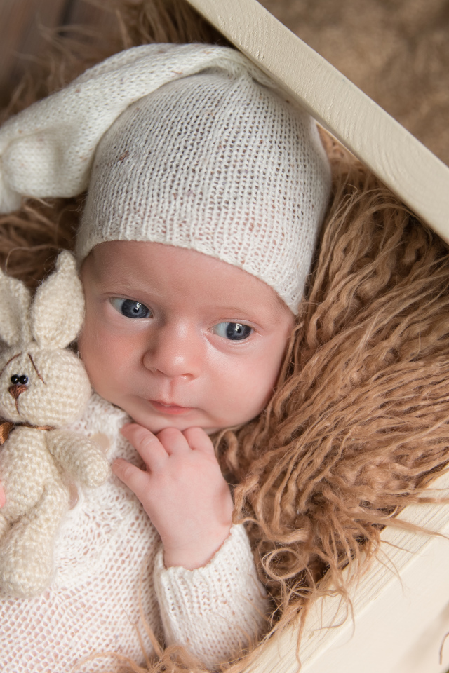 Маленький ребенок в вязанном костюме с зайчиком