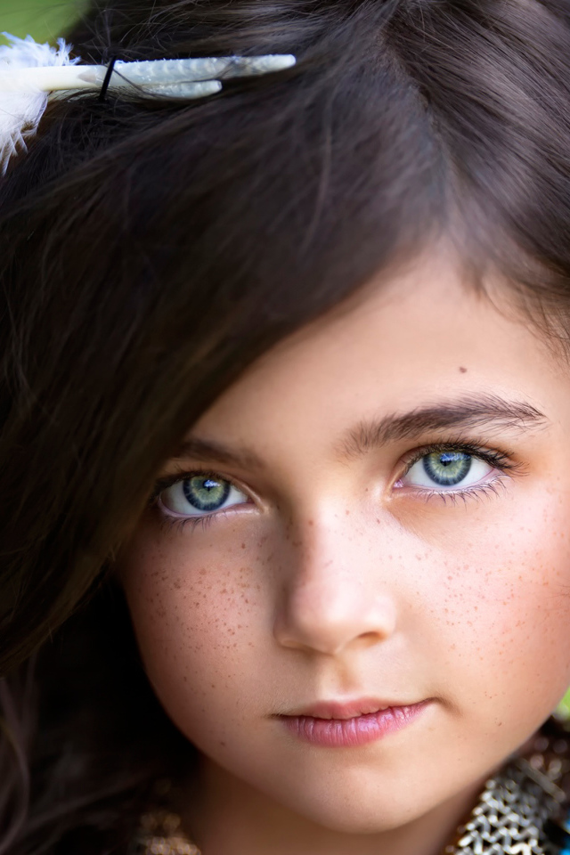 Маленькая красивая девочка с белым пером в волосах