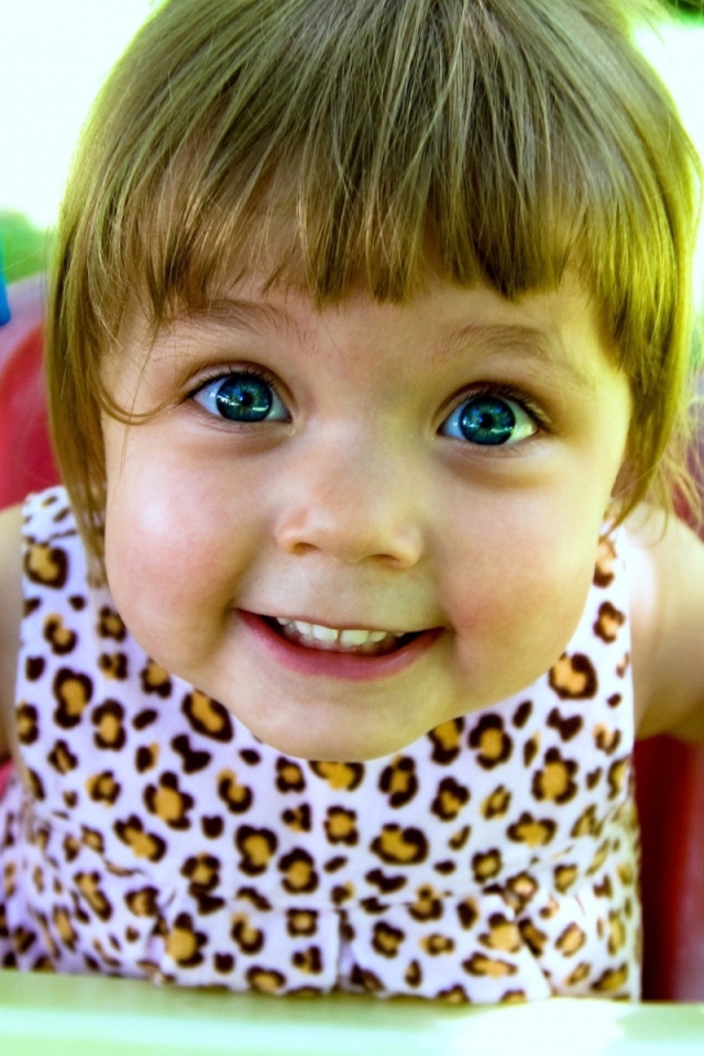 Маленькая голубоглазая девочка на качели