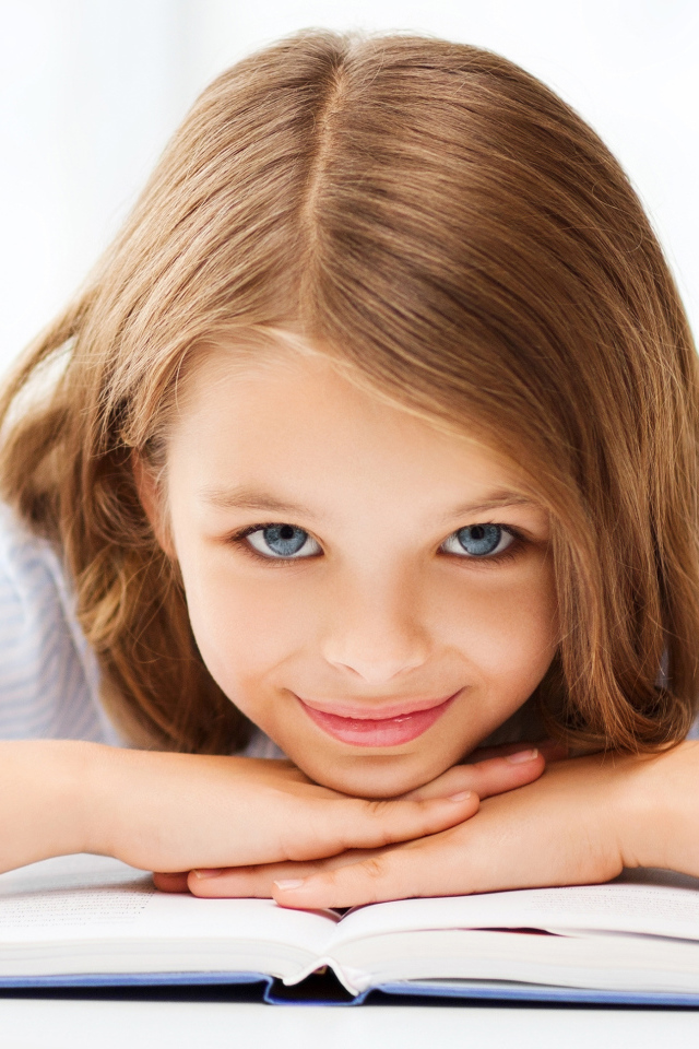 Маленькая голубоглазая девочка школьница с книгой 