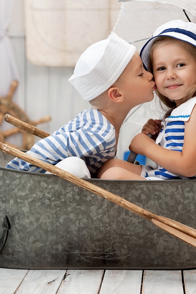 Маленькие мальчик и девочка сидят в железном корыте