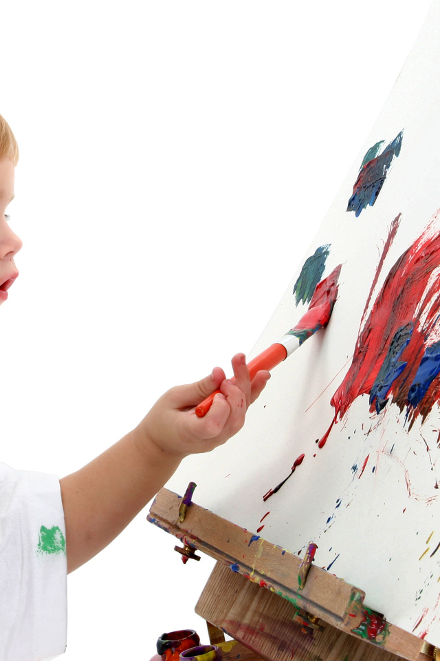 Маленький мальчик рисует красками 