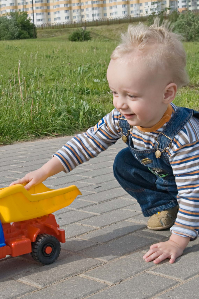 Маленький мальчик играет с машинкой