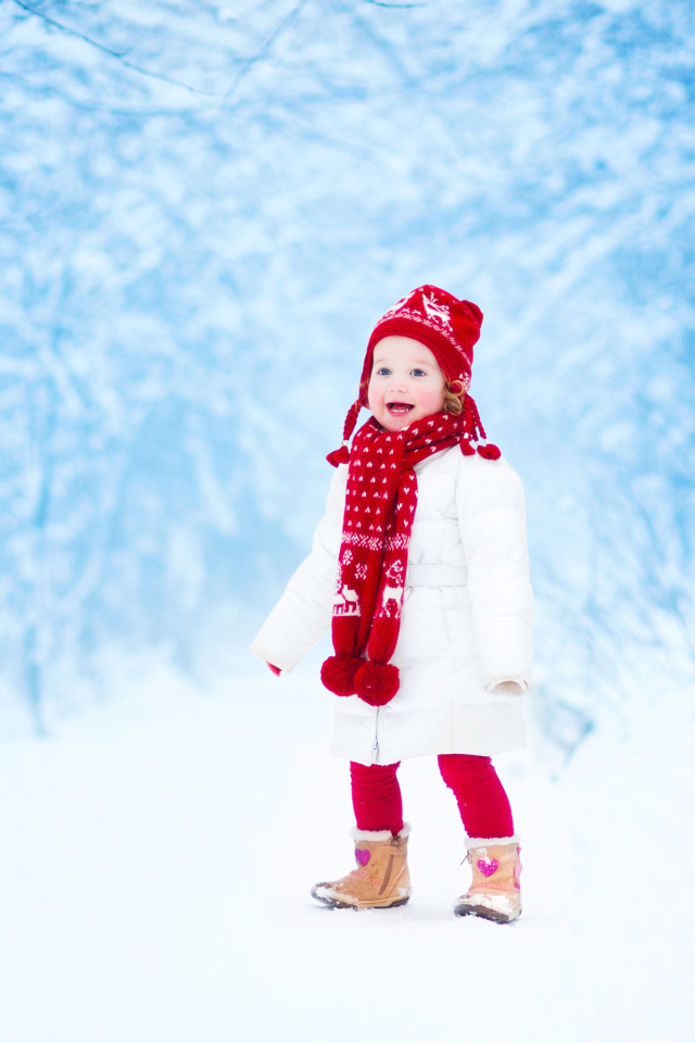 Маленькая веселая девочка в зимнем лесу