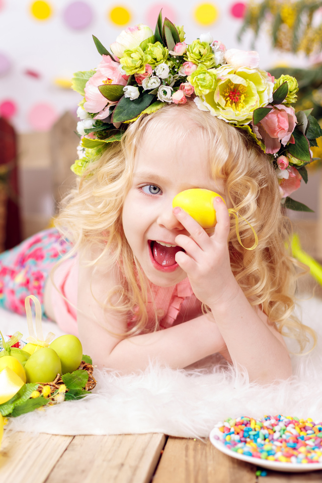 Маленькая веселая девочка с пасхальными яйцами