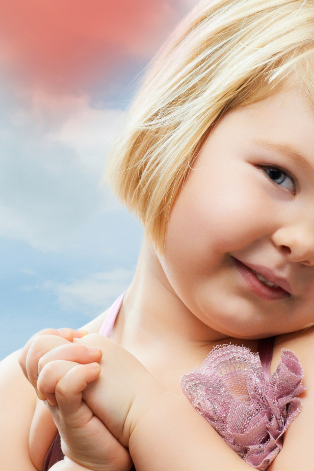 Маленькая милая девочка на фоне красных сердечек