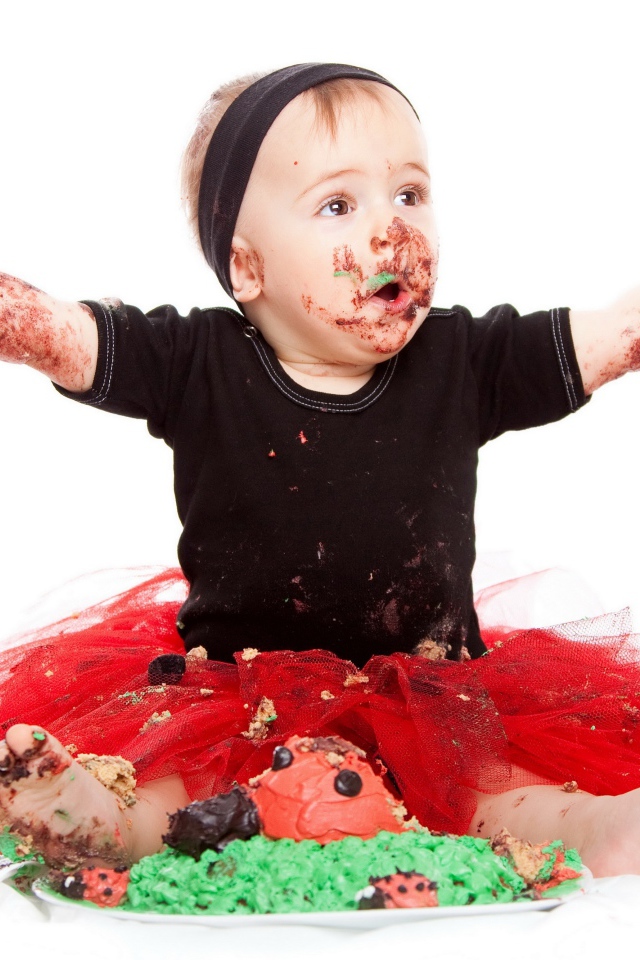 Маленькая смешная девочка в торте на белом фоне