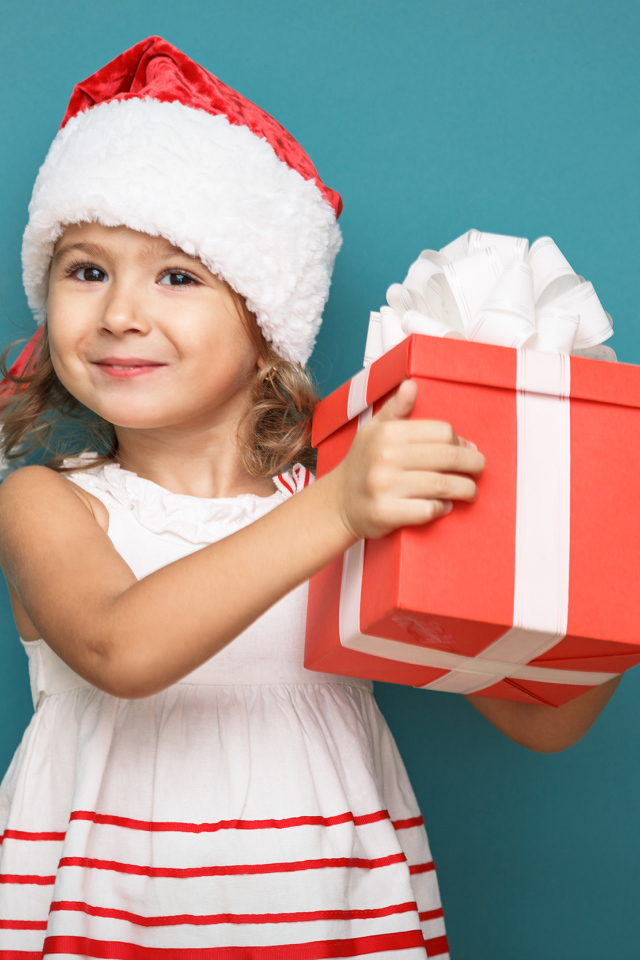 Новогодние подарки. Ребенок дарит подарок. Ребенок держит в руках елочную игрушку. Ребенок получает сувенир.