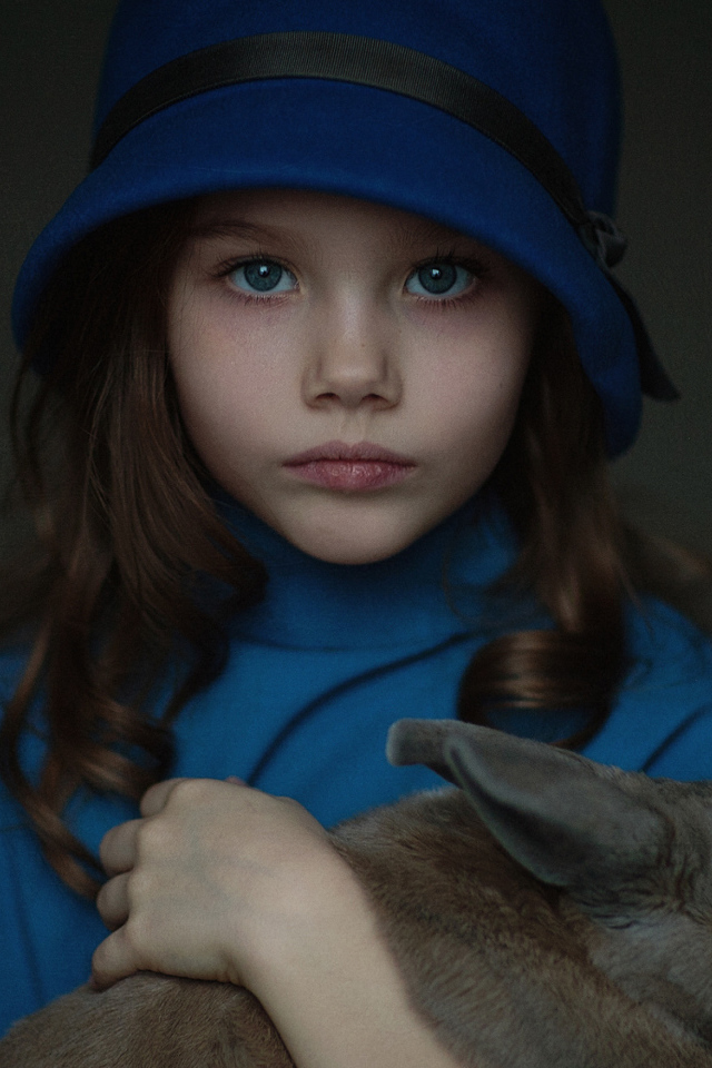 Маленькая девочка в синей шляпе с кроликом