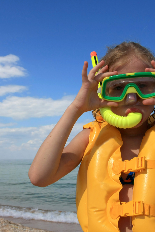 Маленькая девочка в маске и спасательном жилете на море