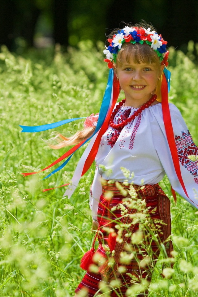 Маленькая девочка в костюме с венком на голове