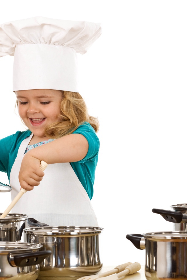 Маленькая девочка в костюме повара на кухне