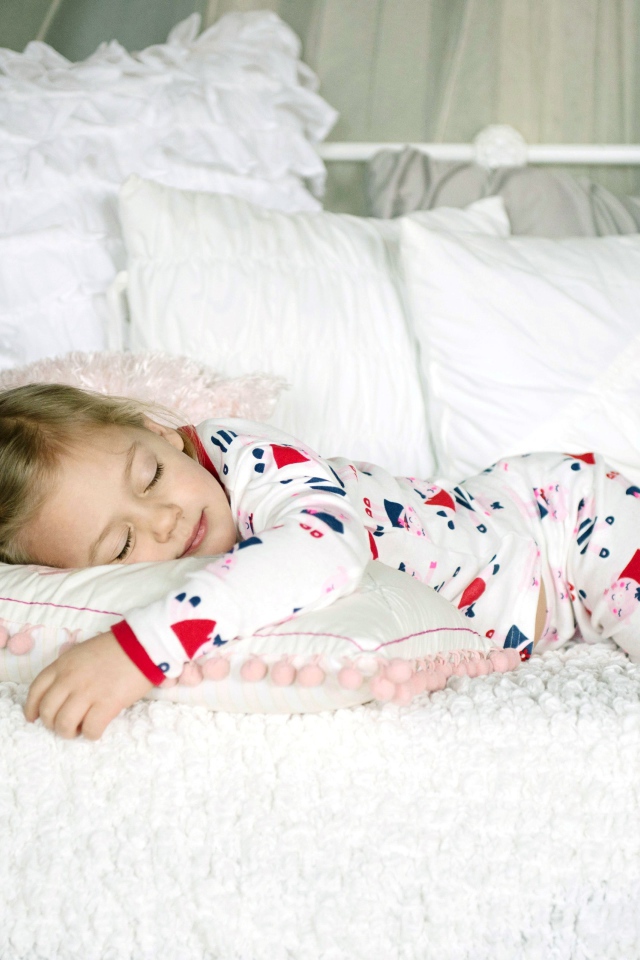 Маленькая девочка спит на подушке