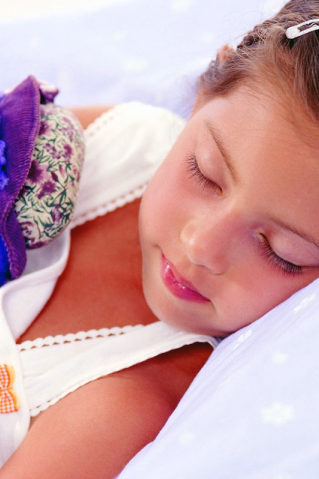 Маленькая девочка спит с игрушкой