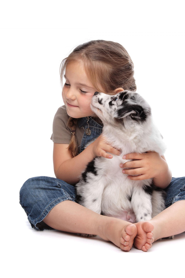 Маленькая девочка с щенком на белом фоне