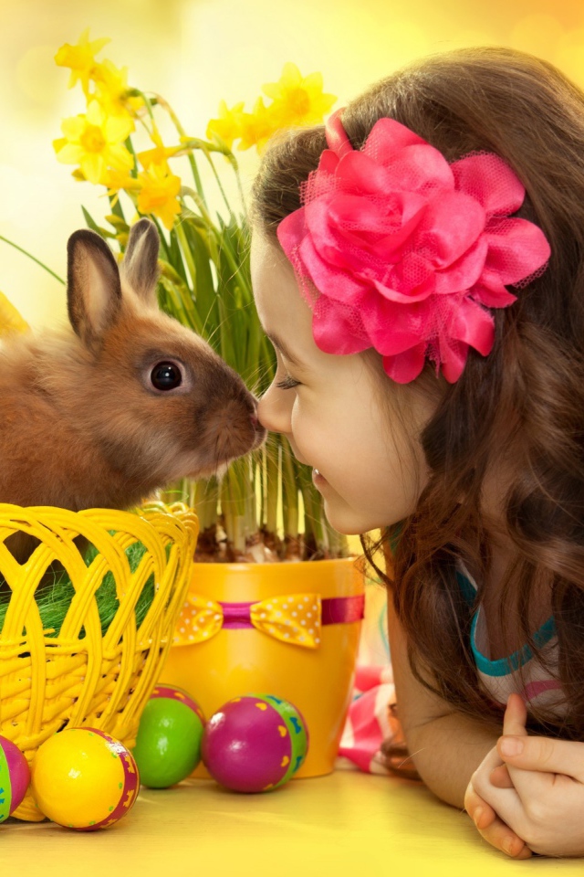 Маленькая девочка с кроликом в корзине на праздник Пасха