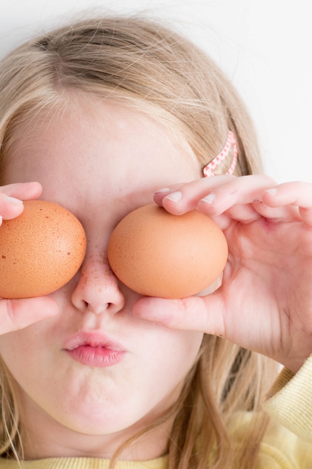 Маленькая девочка с яйцами в руках