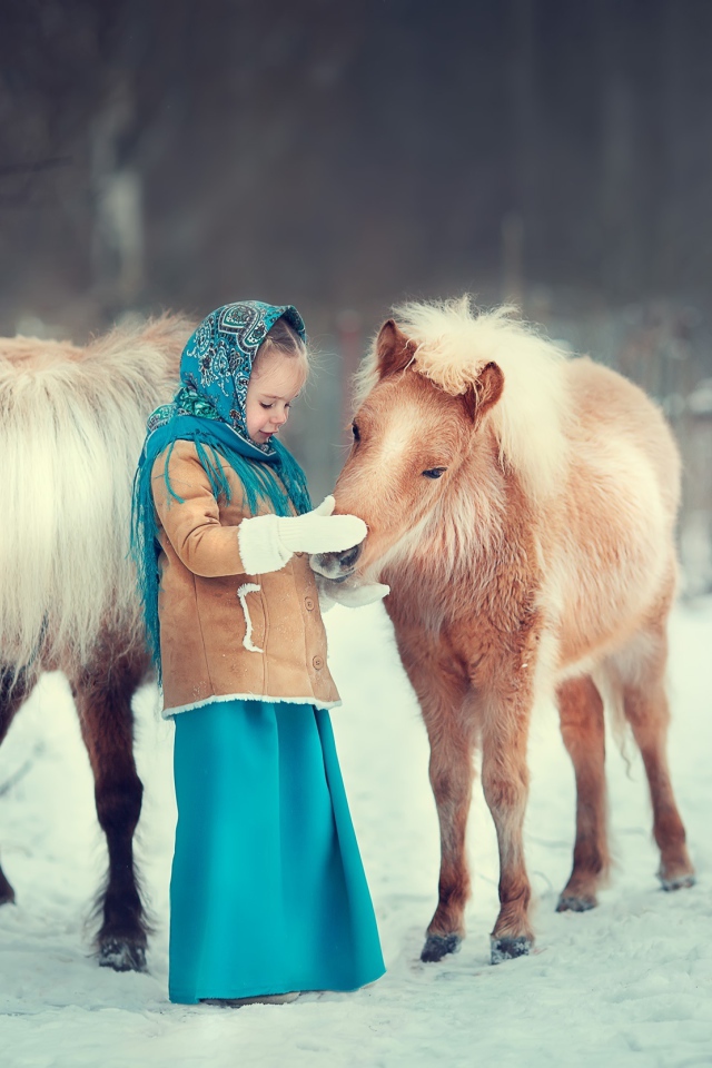 Little girl with pony in winter