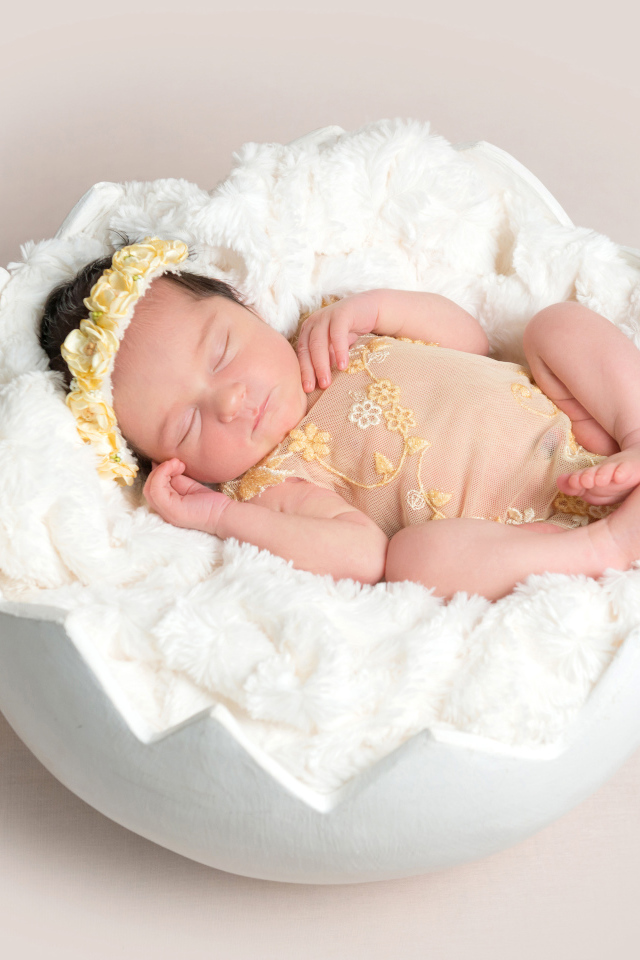 Маленькая новорожденная девочка в забавной колыбели