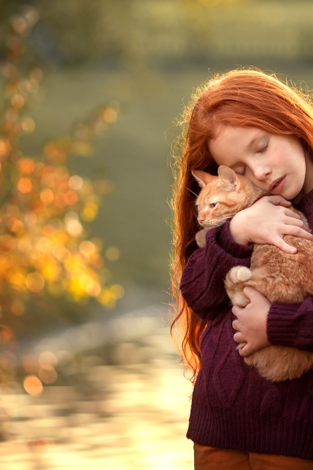Маленькая рыжеволосая девочка с котенком на руках