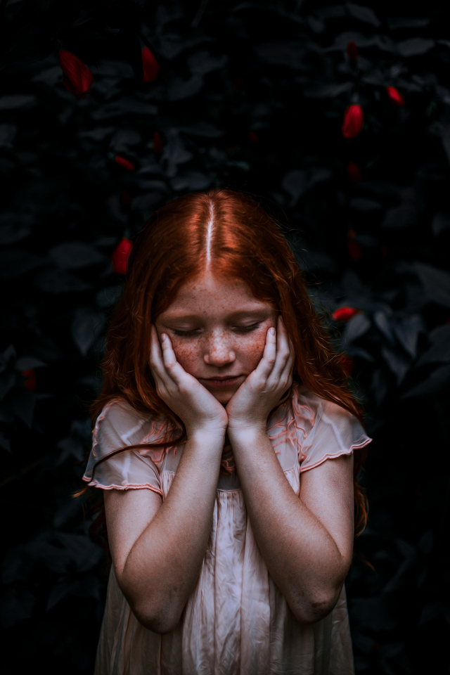 Маленькая рыжеволосая девочка с закрытыми глазами 