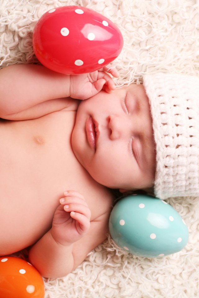 Маленький спящий ребенок с пасхальными яйцами