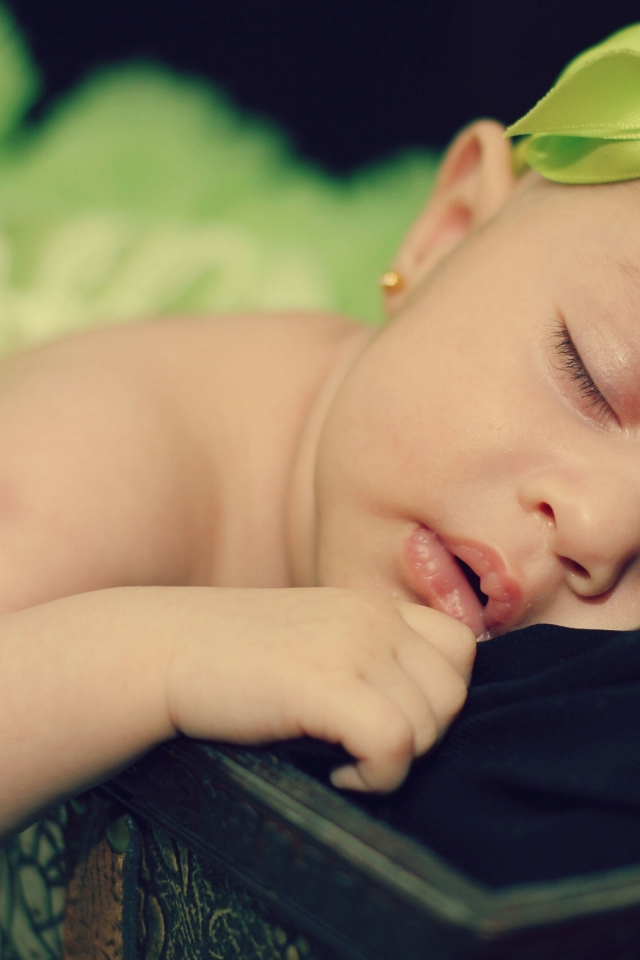 Маленькая спящая девочка с ленточкой на голове