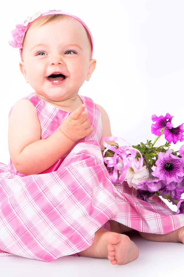 Маленькая улыбающаяся девочка с букетом петунии на белом фоне