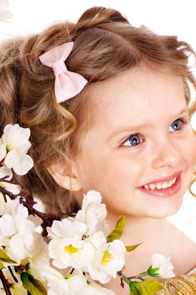 Маленькая улыбающаяся девочка с цветущей веткой