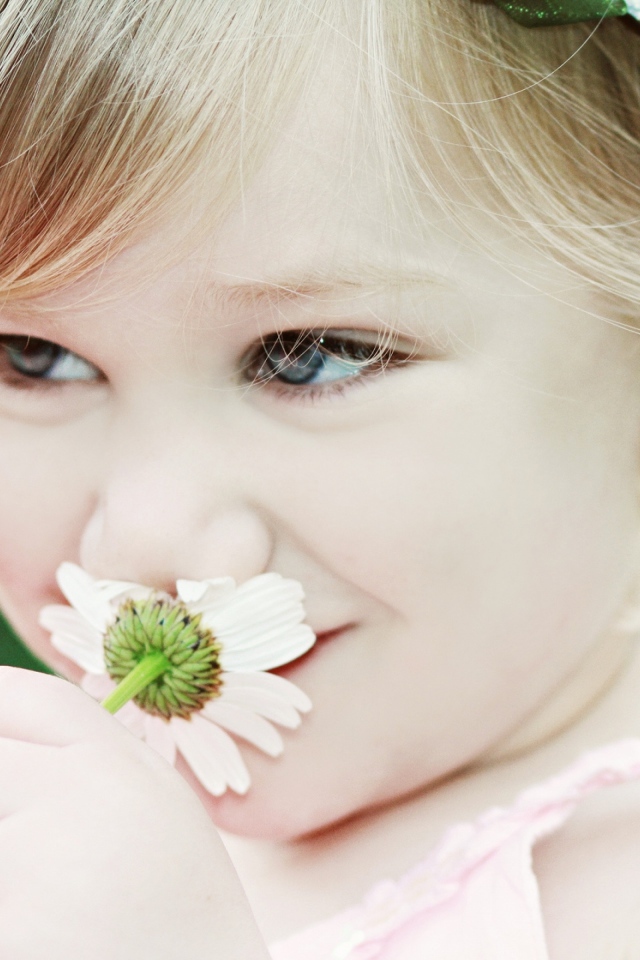 Милая девочка с красивыми глазами с ромашкой