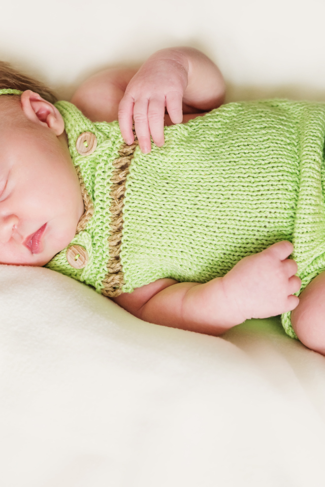 Спящий младенец в вязаной одежде
