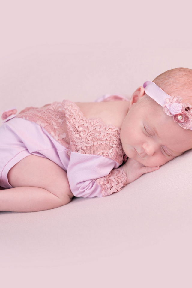 Спящий грудной ребенок на розовом фоне