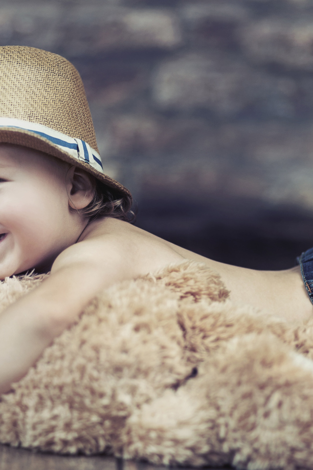 Улыбающийся мальчик обнимает игрушку