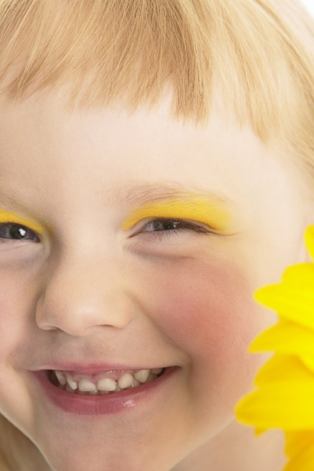 Улыбающаяся девочка с желтым цветком герберы