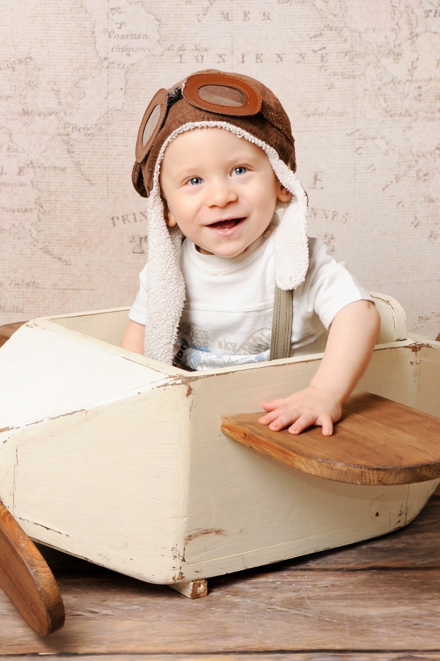 Улыбающийся маленький мальчик в игрушечном самолете