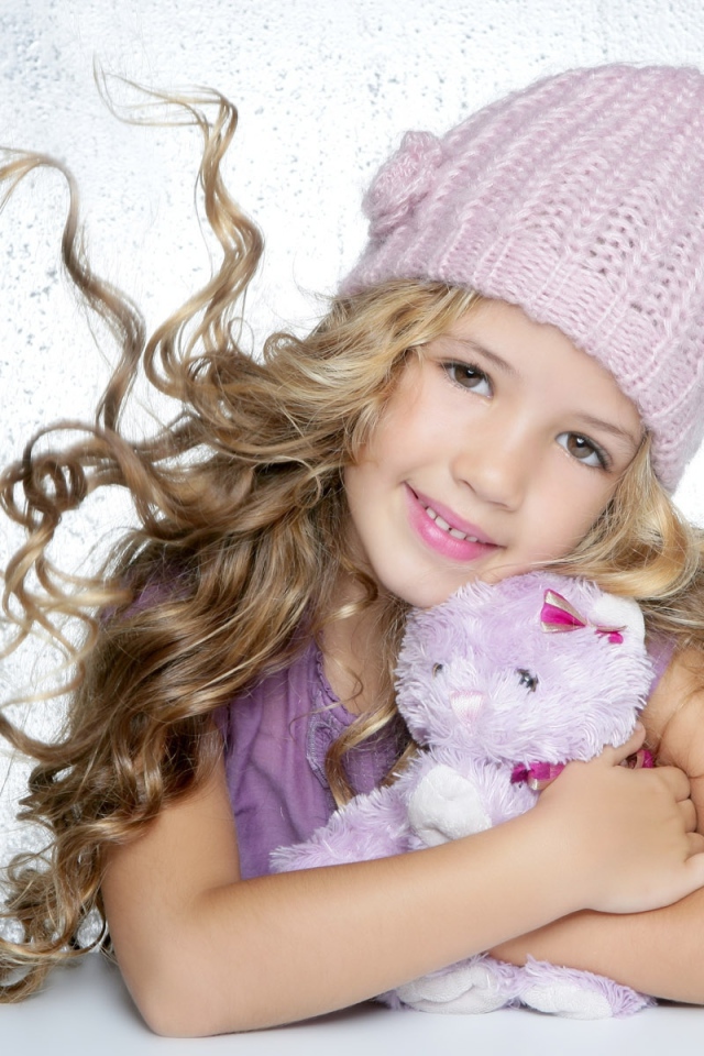 Милая светловолосая девочка с игрушкой