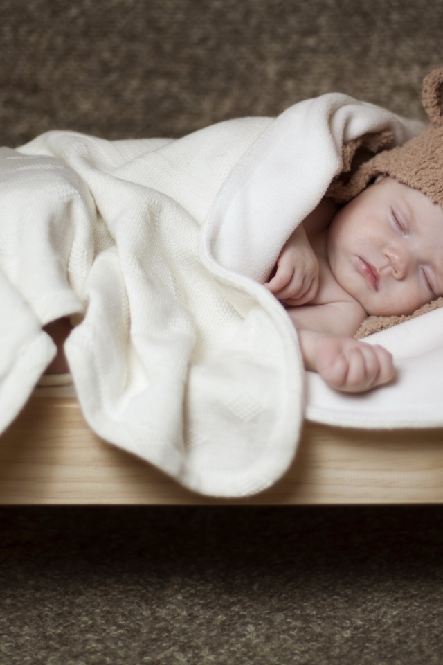 Грудной ребенок спит в маленькой кроватке