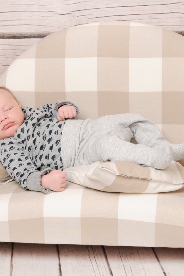 Грудной ребенок спит на диване