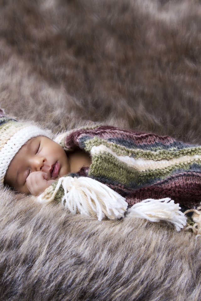 Младенец спит на меховом покрывале