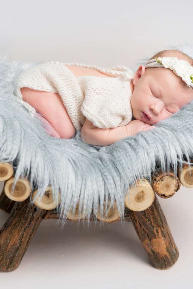 Грудной спящий ребенок лежит на деревянной кроватке