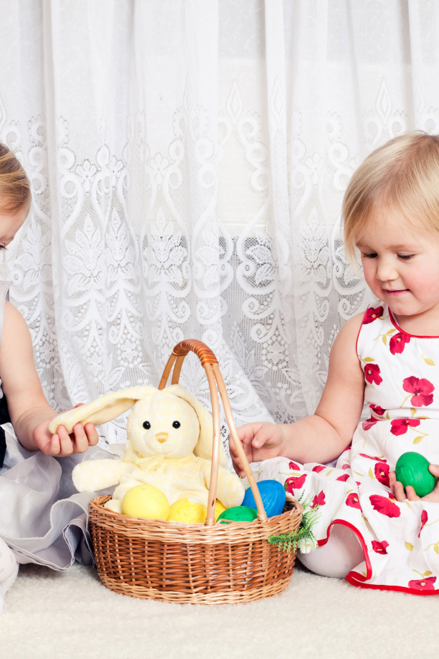 Две маленькие девочки с корзиной пасхальных яиц