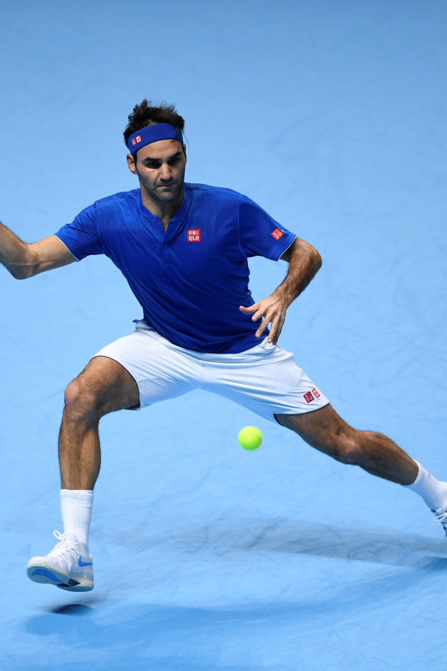 Теннисист Роджер Федерер отбивает мяч ракеткой на корте 