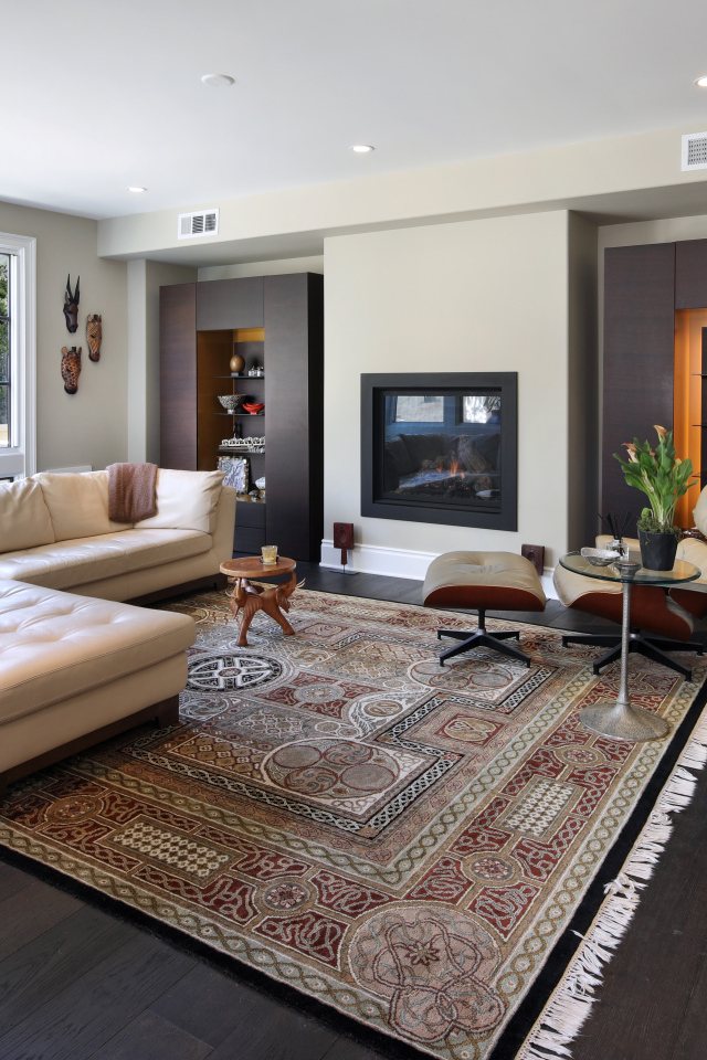 Стильная гостинная комната с белым кожаным диваном и ковром на полу